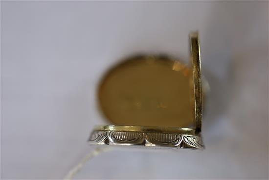 A Victorian silver cusped oval vinaigrette by Nathaniel Mills, the lid engraved with houses,